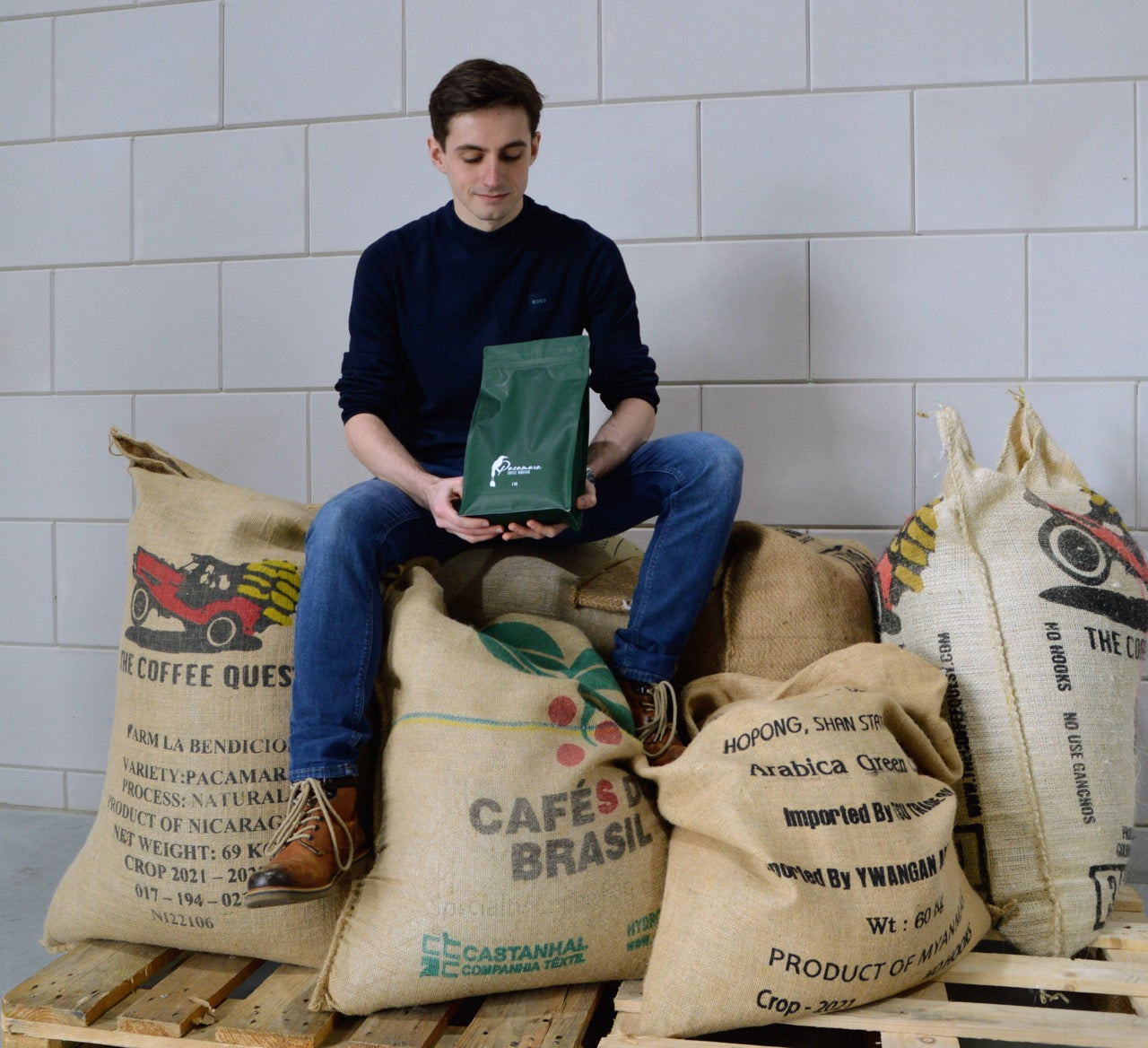 Vincent op balen koffiebonen met zak van Pacamara in handen